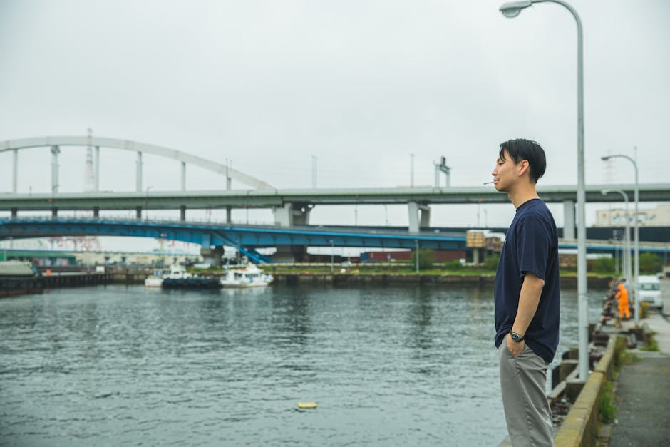 川の近くで喫煙している若い男