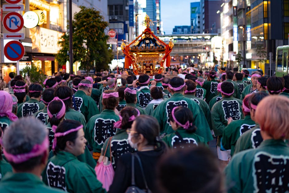 神輿パレードを伴う色鮮やかな日本の伝統的な祭りに参加する群衆。