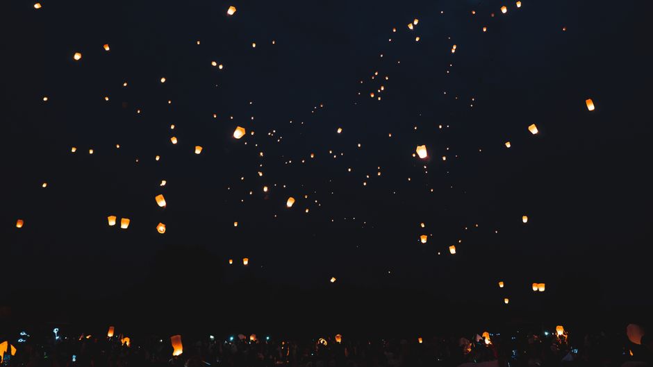 祭りの間に暗い夜空を背景に浮かぶ、照らされた空ランタンの魅力的な景色。