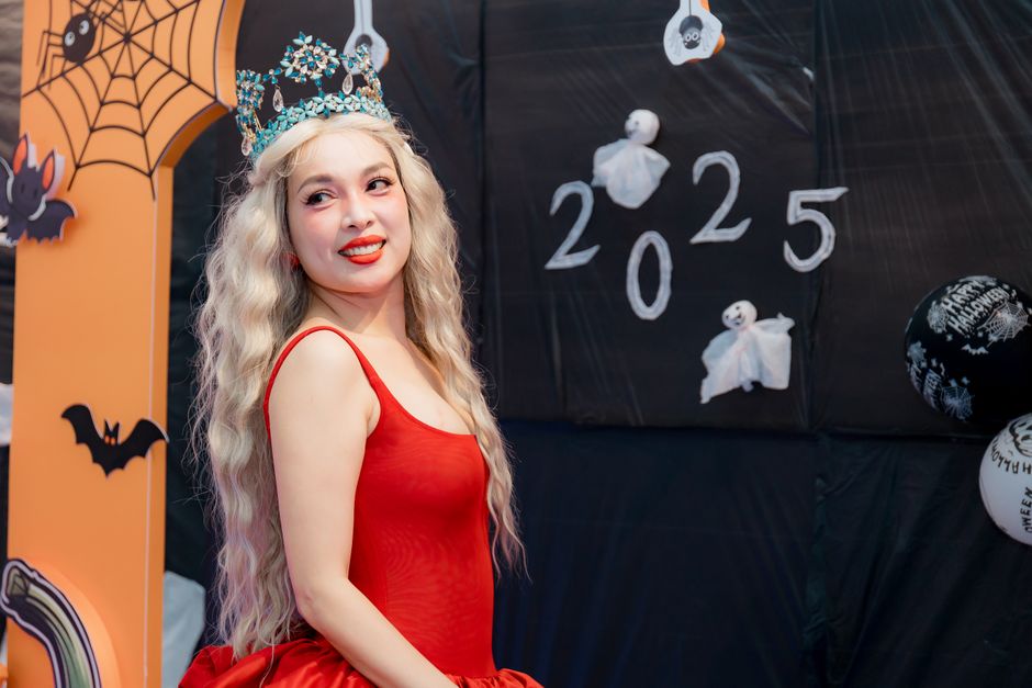 赤いドレスと冠を着た女性が2025年のハロウィンテーマの新年祝いに参加している。