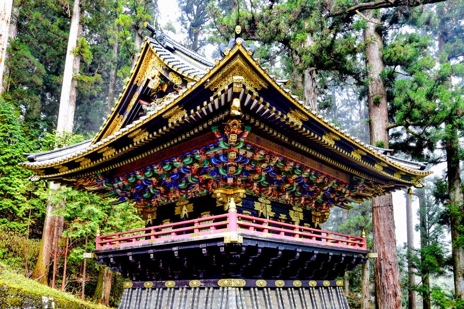 日本の日光にある高い木々の間に立つ美しい装飾の日本の寺院。