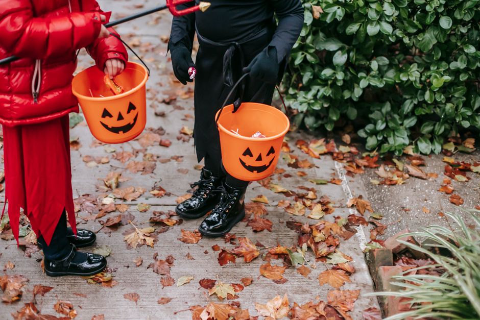 仮装した子どもが持つジャックオーランタンのお菓子バケツ(ハロウィンの持ち物イメージ)